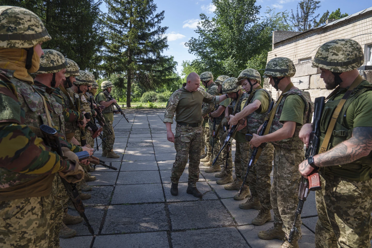 Український військовий інструктор батальйону «Арей» перевіряє зброю засуджених, які приєдналися до української армії, під час навчань на полігоні, Дніпропетровська область, Україна, субота, 22 червня 2024 року.